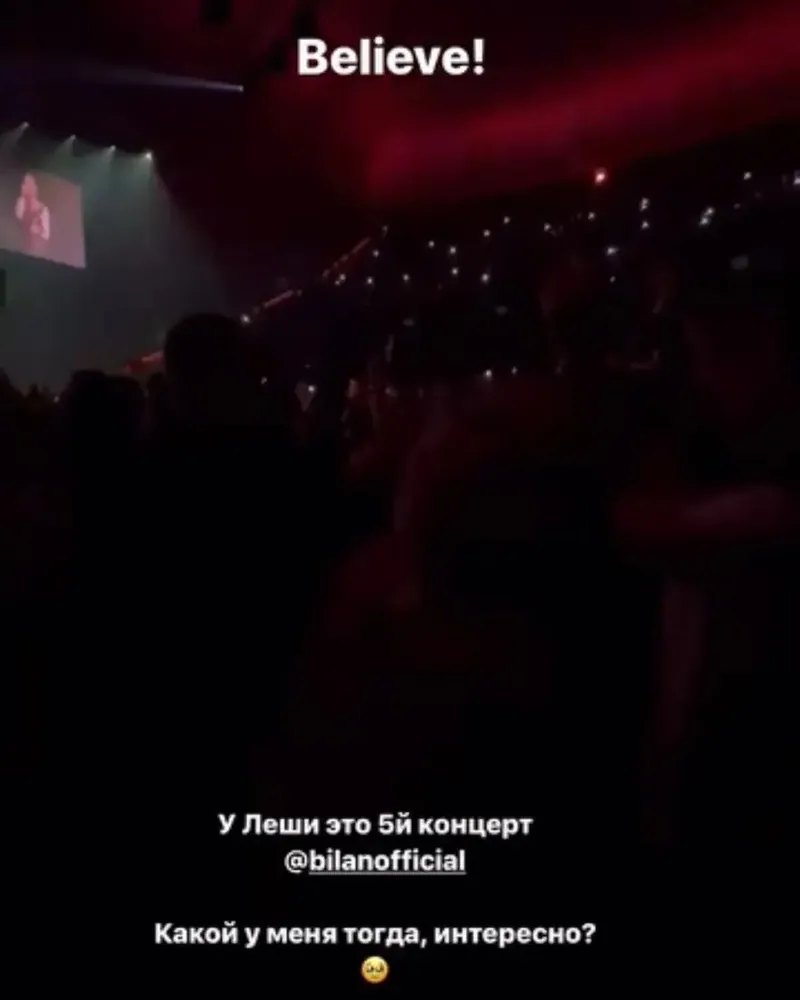 Тёмный зал на концерте, сверху надпись «Believe!», снизу: «У Леши это 5-й концерт. Какой у меня тогда, интересно?»